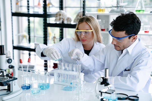 Wetenschappers maken testen met reageerbuis terwijl ze onderzoek doen naar wetenschappelijk laboratorium Premium Foto