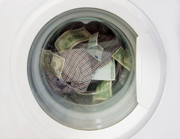 Witwassen van dollars en euro's in een wasmachine samen met linnengoed. Premium Foto