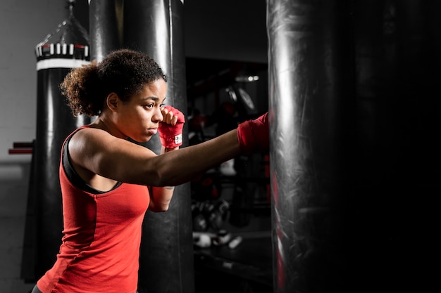 Zijdelings atletische vrouw opleiding in bokscentrum Gratis Foto
