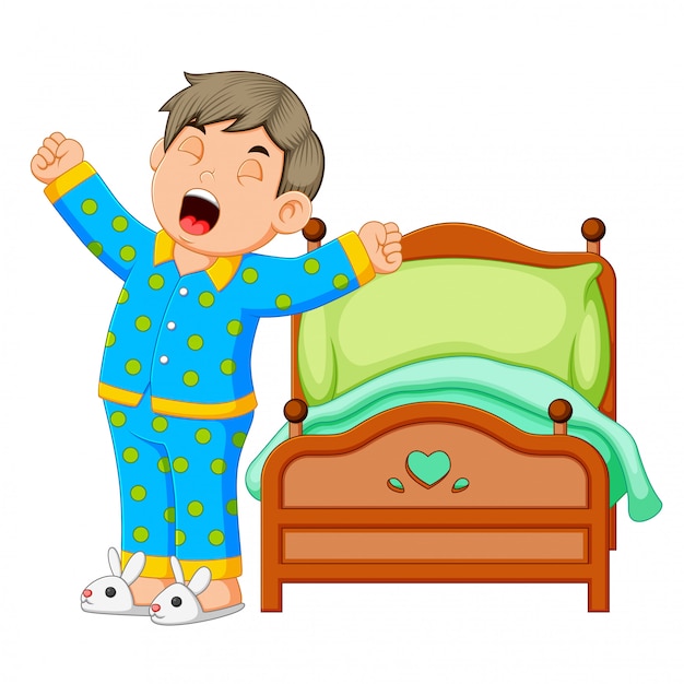 Een jongen wordt wakker en rekt zich uit in de ochtend Premium Vector