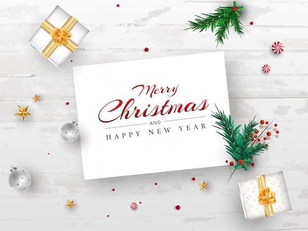 Prettige kerstdagen en gelukkig nieuwjaar berichtkaart met pijnboombladeren, rode bessen, ster, kerstballen en geschenkdozen op witte houten textuur achtergrond. Premium Vector